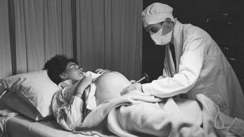 Obstetrician listening to baby heartbeat, 1956