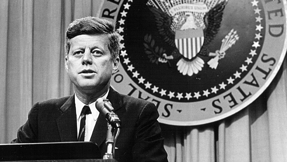 President John F. Kennedy in front of presidential seal