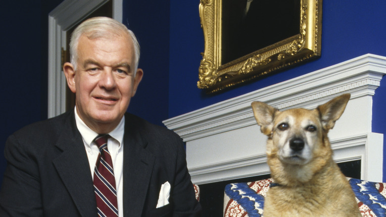 Tom Foley dark suit smiling with dog