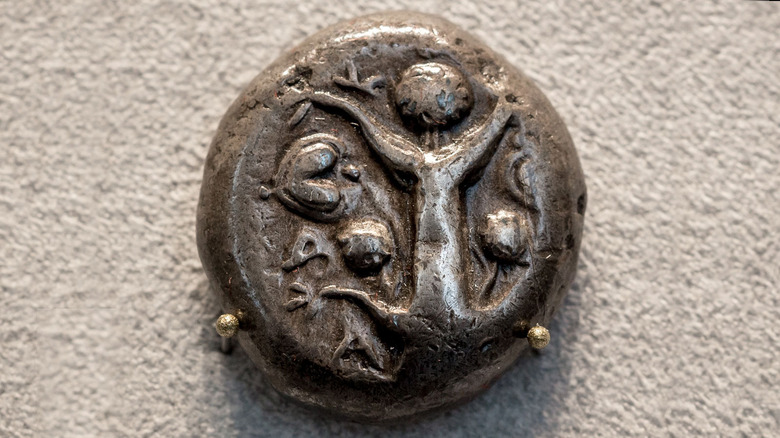 Silver coin with a silphium plant and seed.