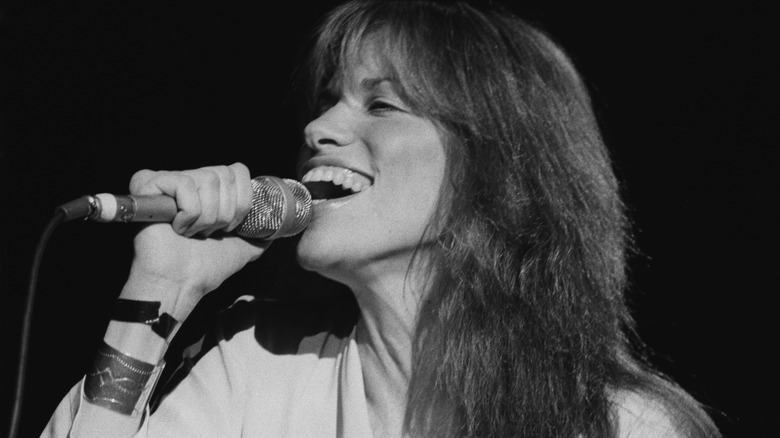 Carly Simon singing into microphone