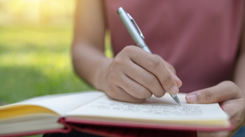 teen writing in notebook