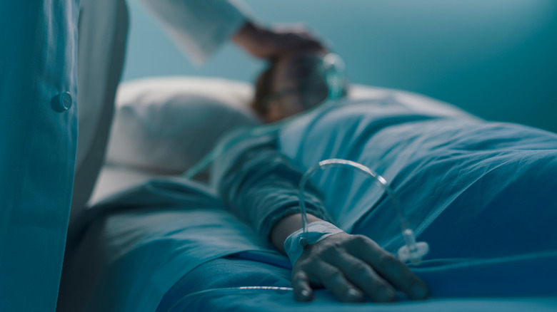 patient in hospital bed with IV in arm