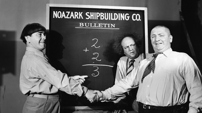 The Three Stooges in front of a chalkboard