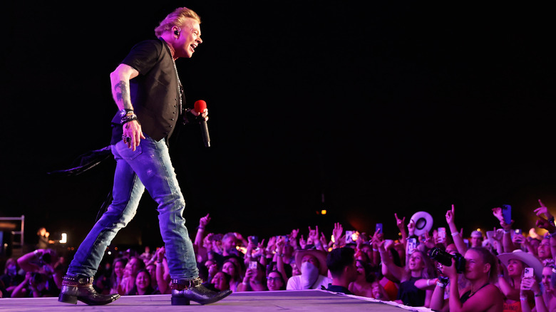 Axl Rose of Guns N' Roses approaches crowd at end of stage