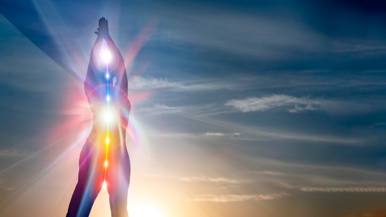 Woman in yoga pose with white light of kundalini energy