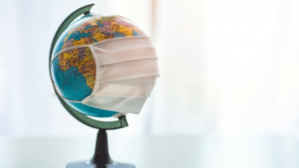 Earth globe with medical disposable face mask. 