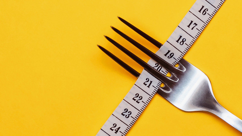 fork threaded through with measuring tape