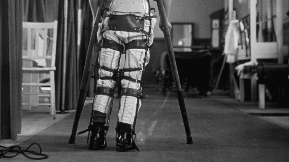 A child suffering from Infantile Paralysis learning to walk with the aid of a special support, at Queen Mary's Hospital