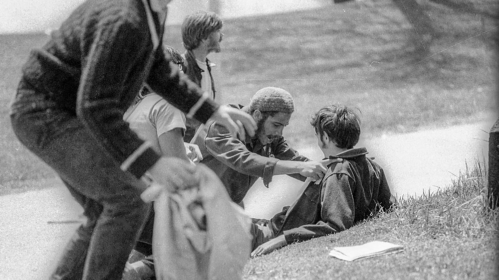 Students kneel to help John Cleary who was shot in the chest by the National Guard