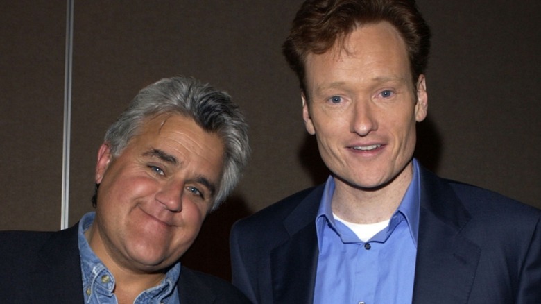 Jay Leno smiling with Conan O'Brien