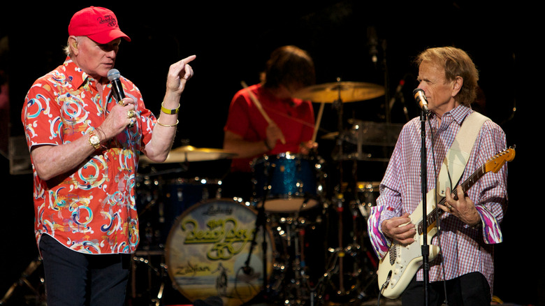 mike love and al jardine staring at each other on stage