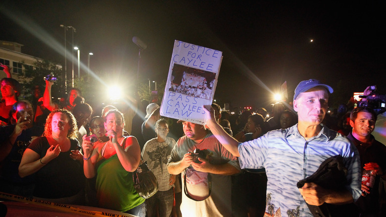 Man holding a sign reading "Justice for Caylee Pass Caylee's Law"