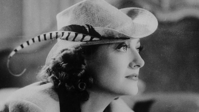 A young Joan Crawford models a fancy-feathered hat