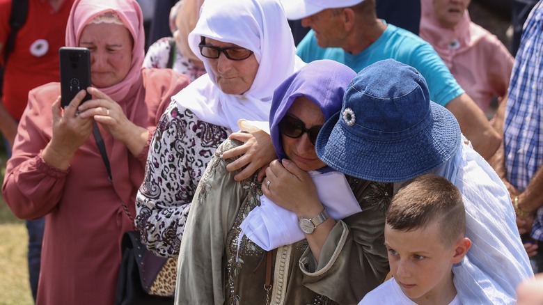 Muslim women crying near Srebrenica gravestones