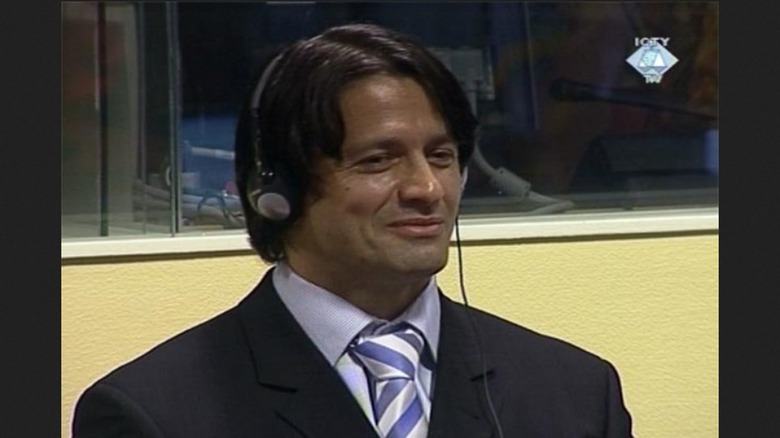 Naser Oric smiling in court with headphones