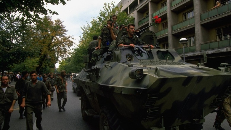 Bosnian Serbs riding on tanks and marching