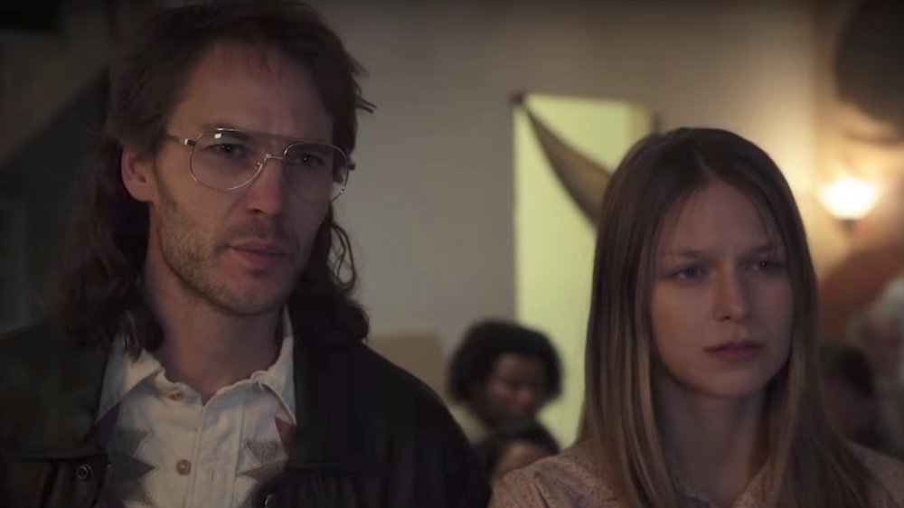 Taylor Kitsch plays David Koresh standing next to Melissa Benoist