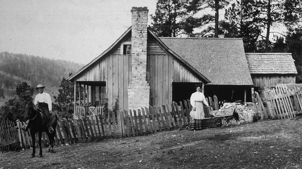 Pioneer home with couple out front working