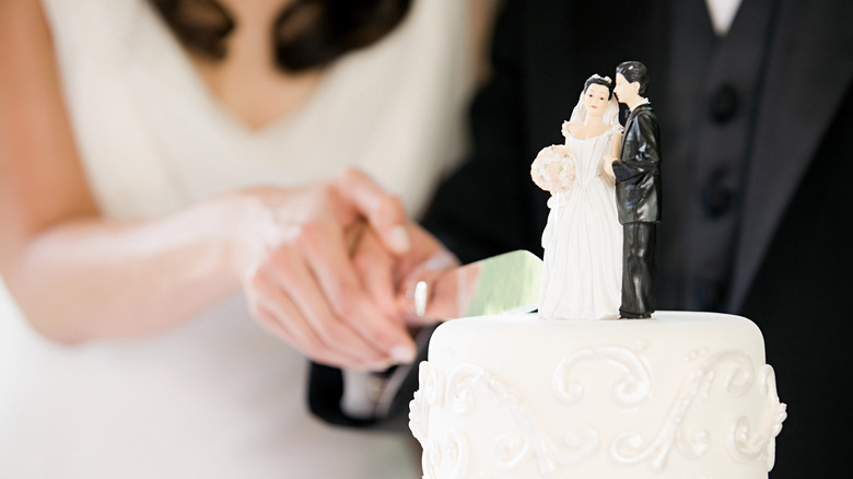 Couple cutting into wedding cake
