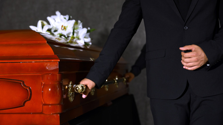 Man standing next to casket