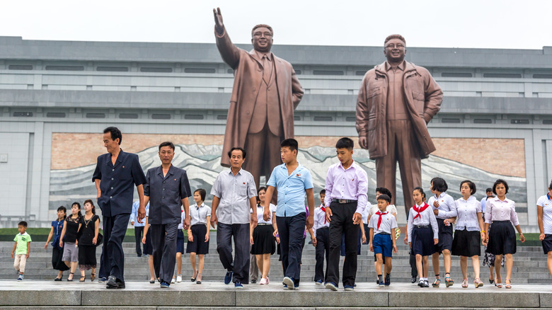 North korean citizens in front of Kim Jing statue