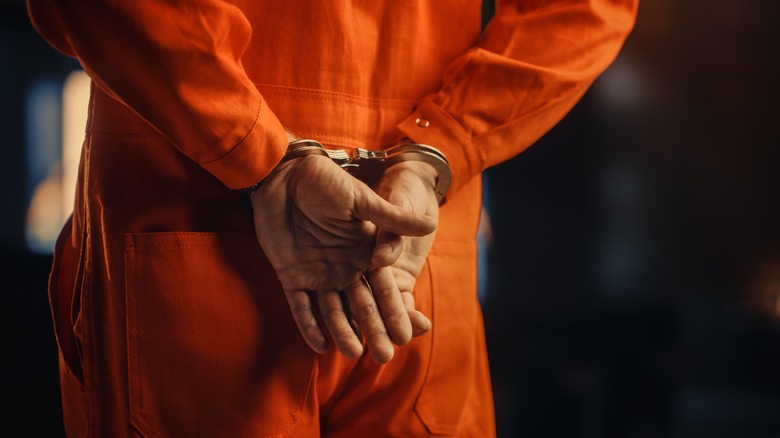 Convict in orange jumpsuit and handcuffs