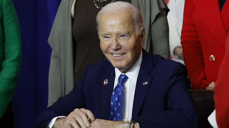 Joe Biden smiling sat at desk