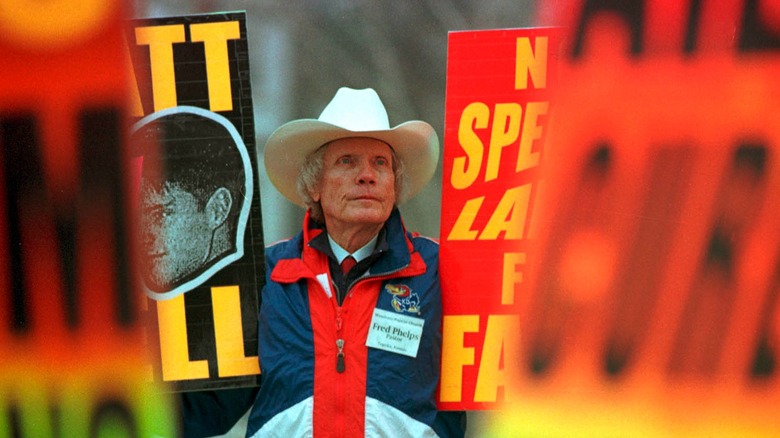 Fred Phelps holding protest signs