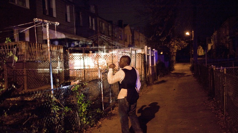 man walking down street wearing bulletproof vest