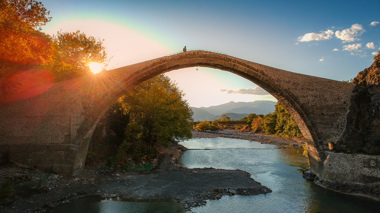 person walking on konitsa bridge