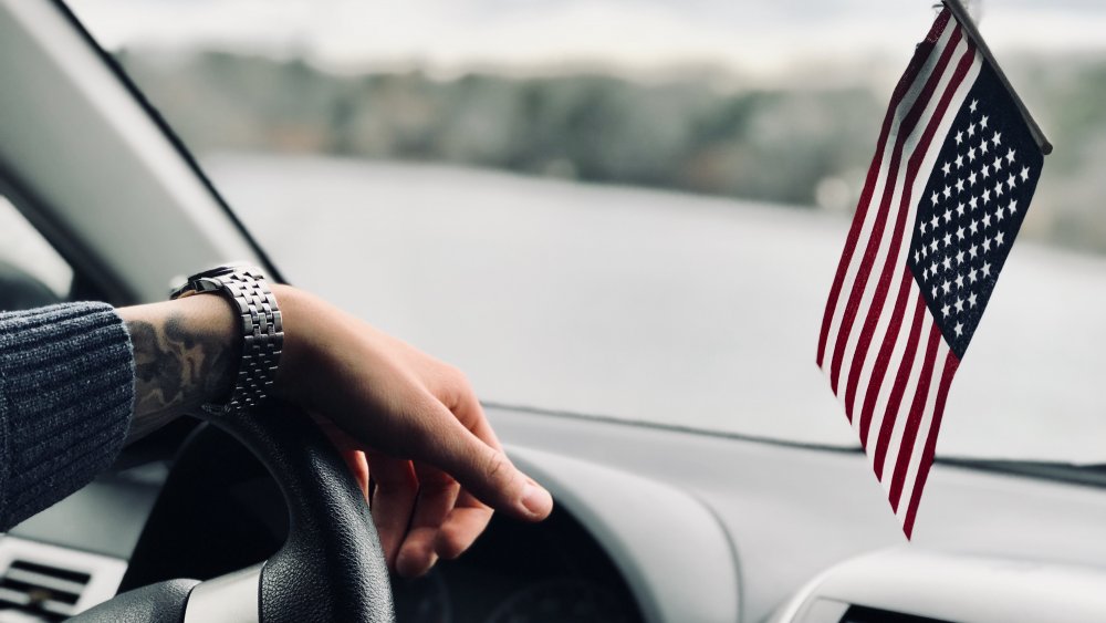 Flag and hand on wheel