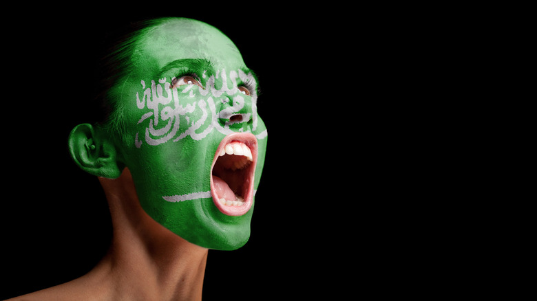 woman face painted Saudi Arabia flag