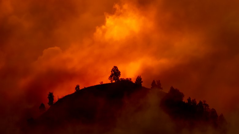 wildfire smoke over tall round hill