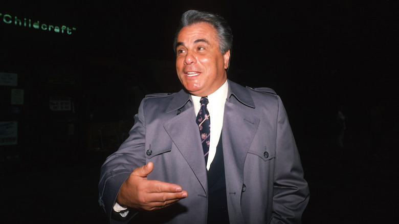 John Gotti gray trench coat smiling