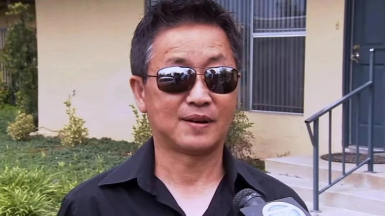 Kwang Chol Joy wearing sunglasses during an interview with local news