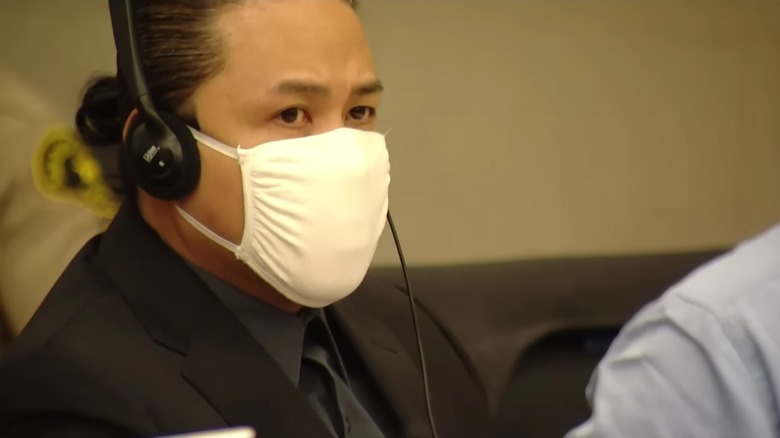 Larry Millete wearing headphones and a mask at his preliminary hearing