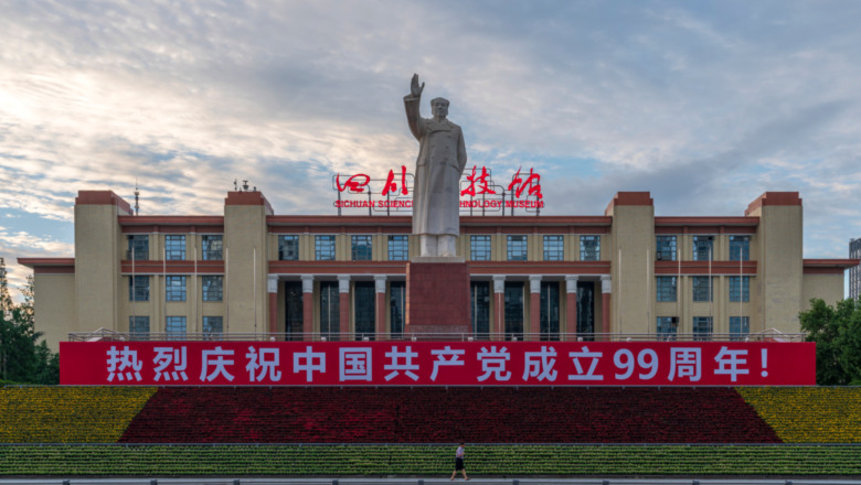 a banner plastered beneath a statue of Mao Zedong 