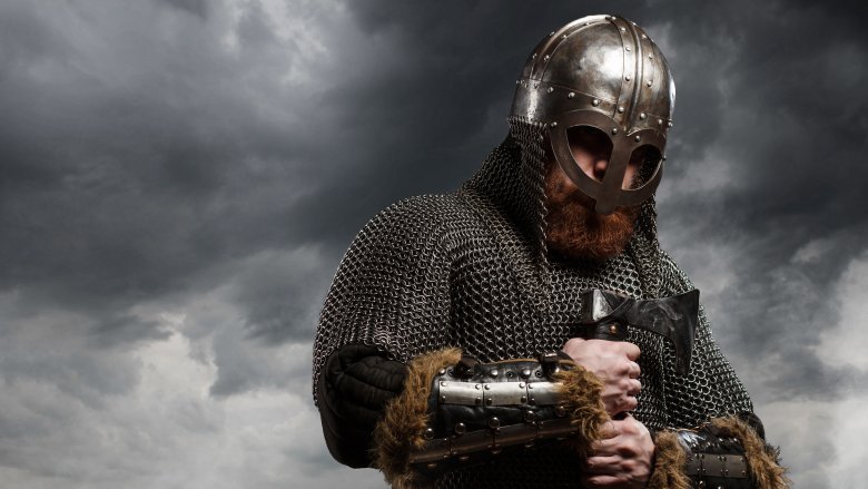 viking chainmail helmet holding sword