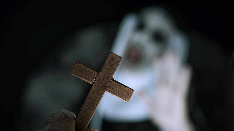 cross against blurry possessed nun