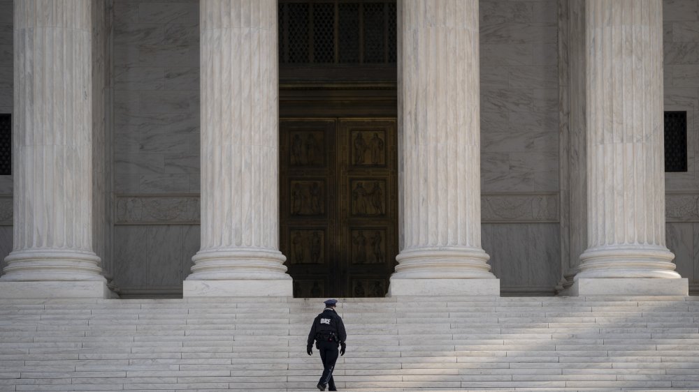 Police officer walking up the steps to the Supreme Court