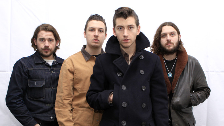 Arctic Monkeys posing in coats