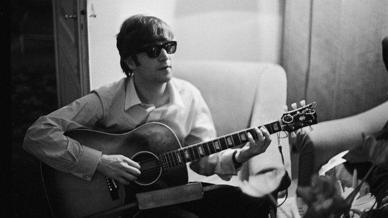 Lennon plays guitar