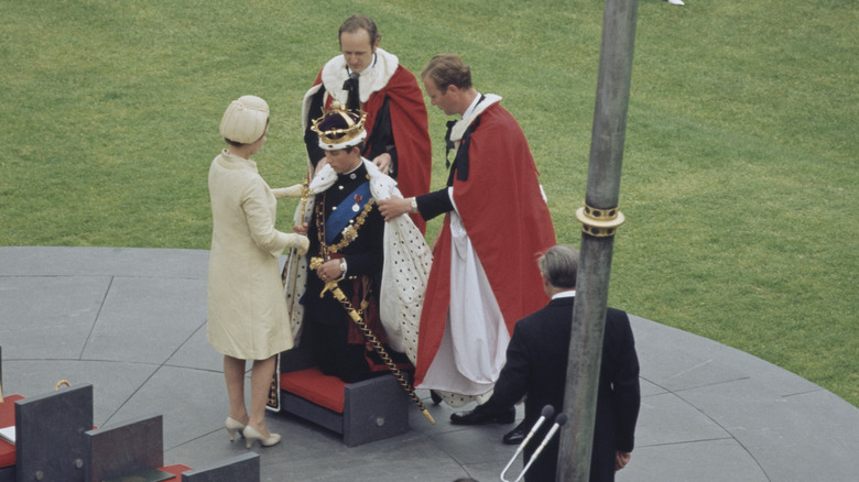 Prince Charles kneels for his investiture