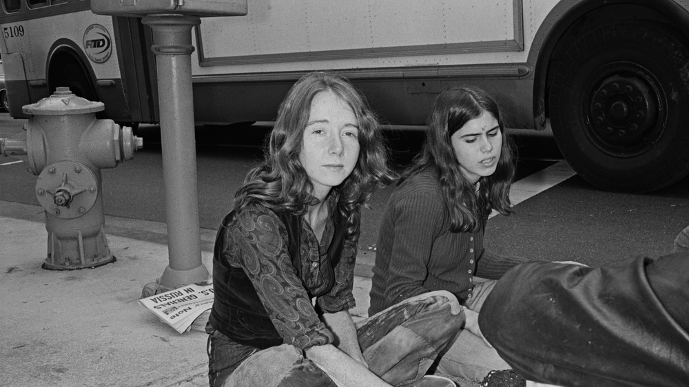 lynette fromme sitting on a sidewalk