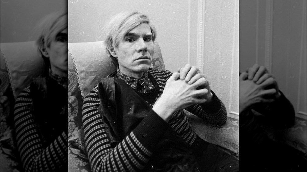 andy warhol sitting with hands clasped