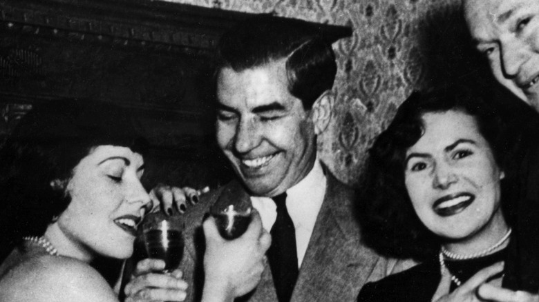 Lucky Luciano holding drink and laughing