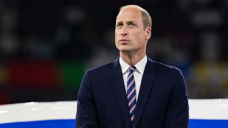 Prince William in dark suit at sports event