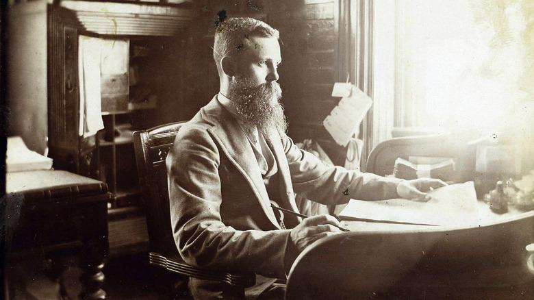 Bearded clerk at desk pen paper