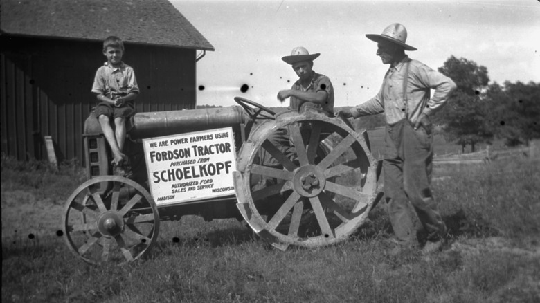 Farmers posing by tractor